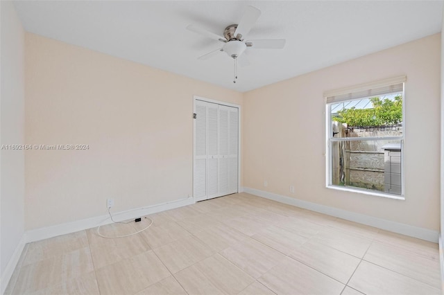 tiled empty room featuring ceiling fan