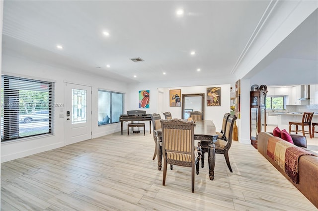 dining room featuring light hardwood / wood-style flooring and ornamental molding