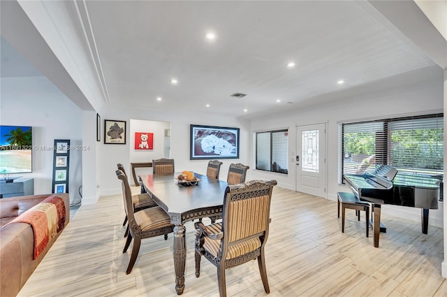 dining area with crown molding and light hardwood / wood-style floors