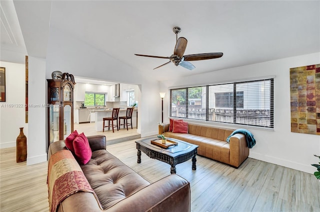 living room with ceiling fan, light hardwood / wood-style floors, and lofted ceiling