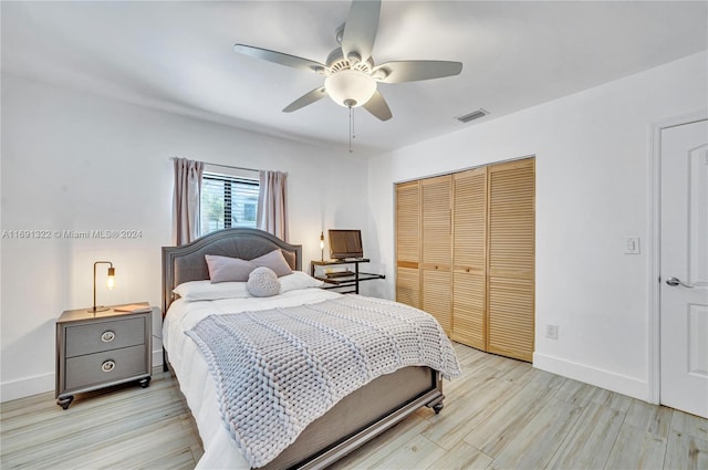 bedroom with ceiling fan, light wood-type flooring, and a closet