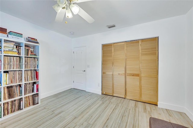 unfurnished bedroom featuring light wood-type flooring, a closet, and ceiling fan