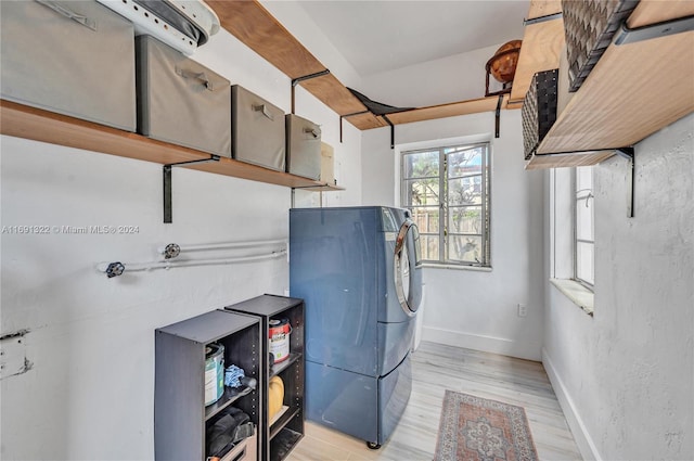 clothes washing area featuring washer / dryer and light hardwood / wood-style flooring