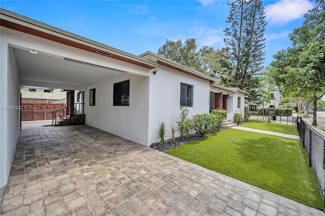 view of home's exterior with a yard and a carport