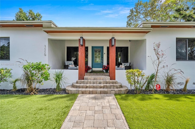 entrance to property with a lawn