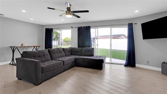 living room featuring light hardwood / wood-style flooring and ceiling fan