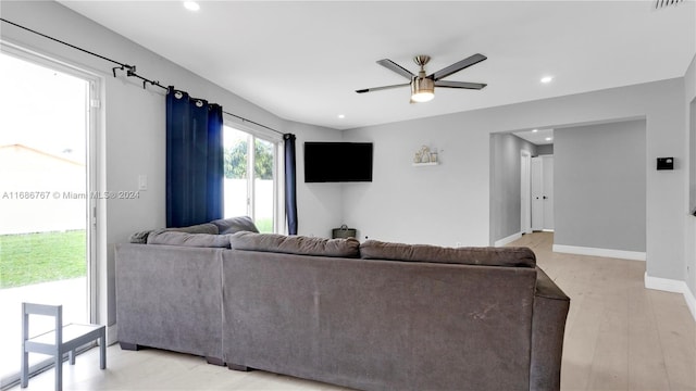 living room with ceiling fan and light hardwood / wood-style flooring