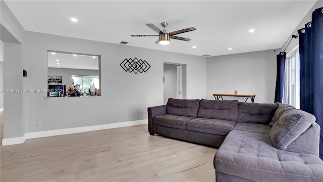 living room with light wood-type flooring and ceiling fan