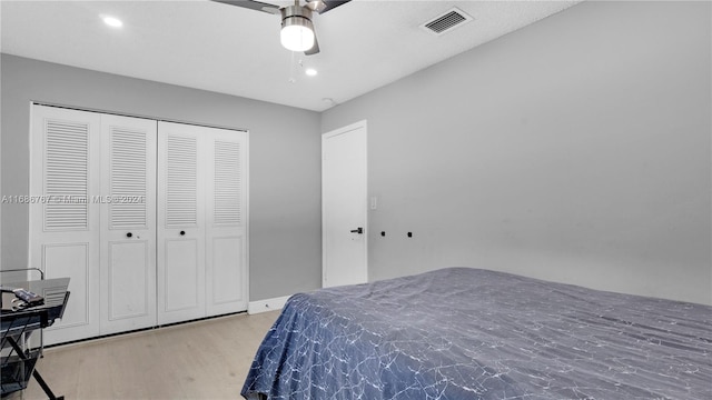 bedroom with light hardwood / wood-style floors, ceiling fan, and a closet