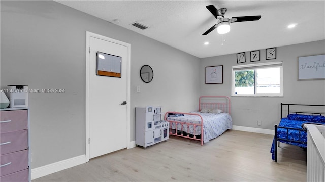 bedroom featuring a textured ceiling, light wood-type flooring, and ceiling fan