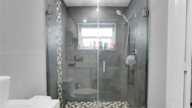 bathroom featuring toilet and an enclosed shower