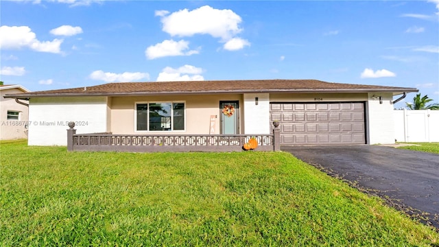 ranch-style home with a garage and a front lawn