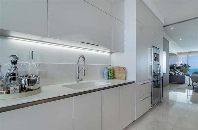 16901 Collins Ave Unit 1503, Sunny Isles Beach, FL 33160 - kitchen with a sink, modern cabinets, recessed lighting, white cabinetry, and light countertops