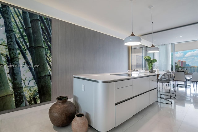 16901 Collins Ave Unit 1503, Sunny Isles Beach, FL 33160 - kitchen featuring white cabinets, modern cabinets, hanging light fixtures, light tile patterned floors, and a kitchen island with sink