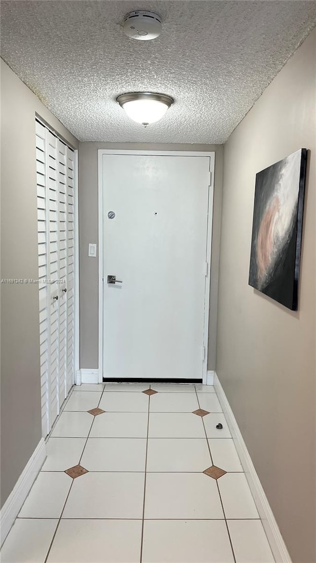 entryway featuring a textured ceiling and light tile patterned flooring