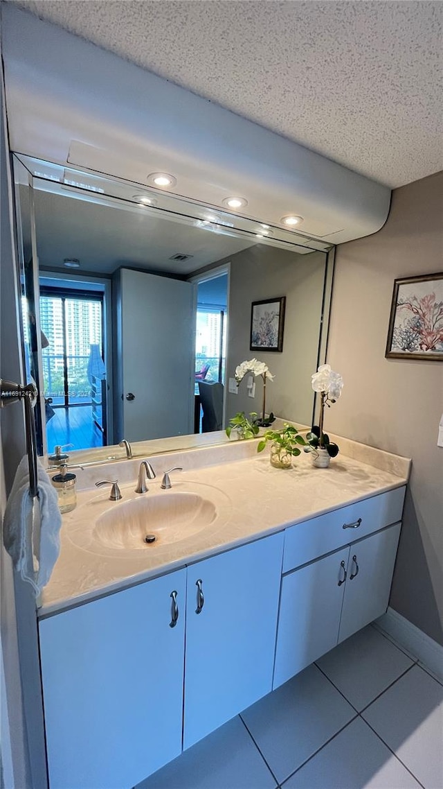 bathroom featuring tile patterned flooring, plenty of natural light, a textured ceiling, and vanity