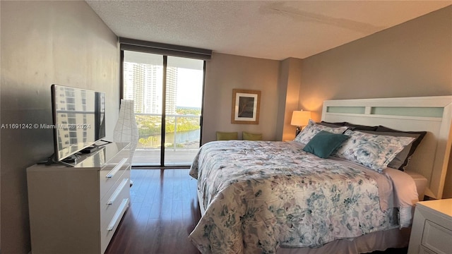 bedroom with a textured ceiling, dark hardwood / wood-style flooring, access to outside, and expansive windows