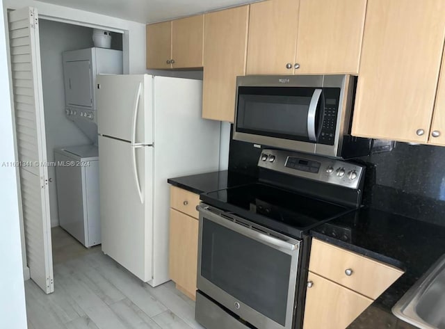 kitchen featuring light hardwood / wood-style floors, stainless steel appliances, light brown cabinetry, and stacked washer / drying machine