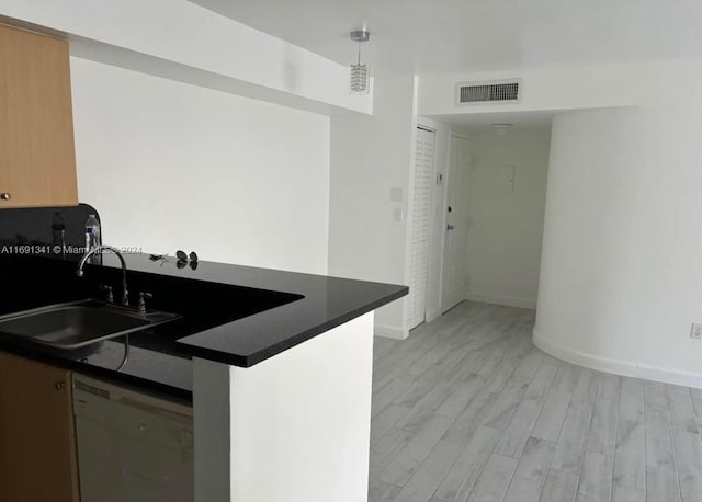 kitchen featuring hanging light fixtures, sink, dishwasher, kitchen peninsula, and light hardwood / wood-style flooring