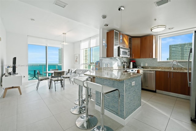 kitchen featuring stainless steel appliances, decorative backsplash, sink, light tile patterned floors, and decorative light fixtures