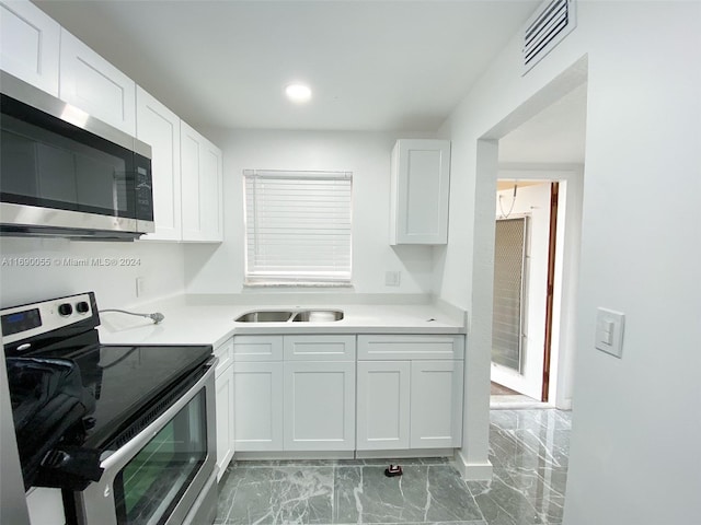 kitchen featuring white cabinets, appliances with stainless steel finishes, and sink