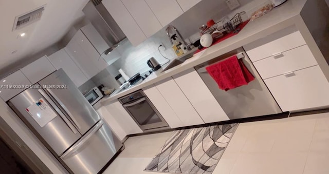 kitchen featuring white cabinets, light tile patterned flooring, and oven