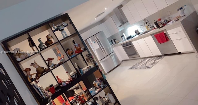 kitchen with white cabinetry and stainless steel refrigerator