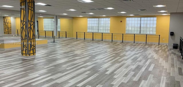 exercise room featuring a drop ceiling and wood-type flooring