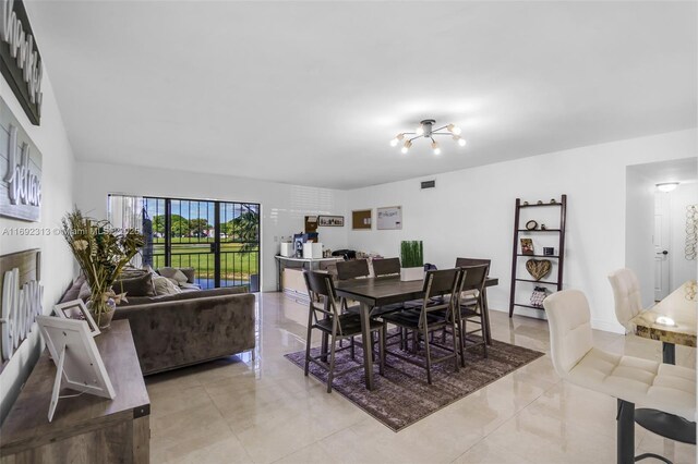 dining room with light tile patterned floors and a notable chandelier