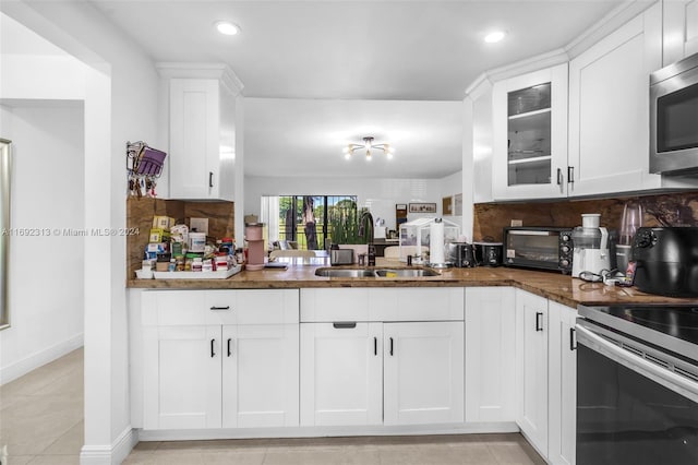 kitchen featuring stainless steel appliances, white cabinetry, and sink