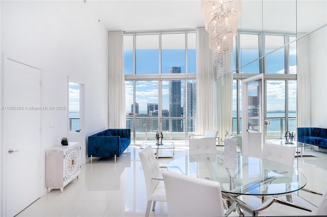 tiled dining space with expansive windows, a high ceiling, a healthy amount of sunlight, and an inviting chandelier