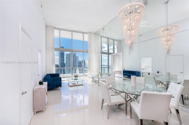 dining area featuring a high ceiling, light tile patterned floors, an inviting chandelier, and floor to ceiling windows