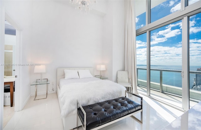 bedroom with a chandelier, tile patterned flooring, a water view, and access to outside