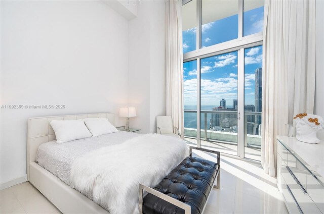 495 Brickell Ave Unit 4103, Miami, FL 33131 - bedroom with access to outside, a towering ceiling, tile patterned floors, a water view, and a wall of windows