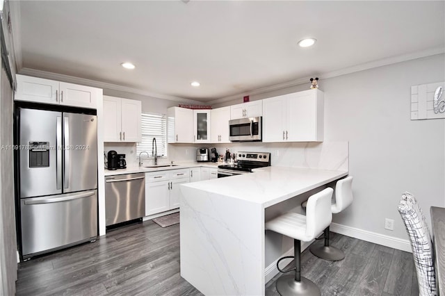 kitchen with white cabinets, stainless steel appliances, crown molding, and sink