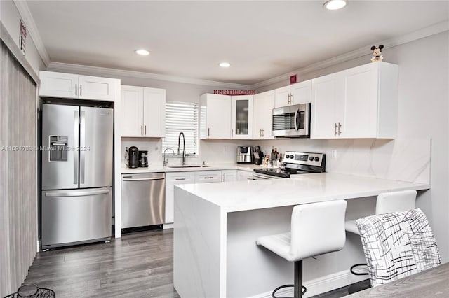 kitchen featuring kitchen peninsula, white cabinetry, sink, and stainless steel appliances