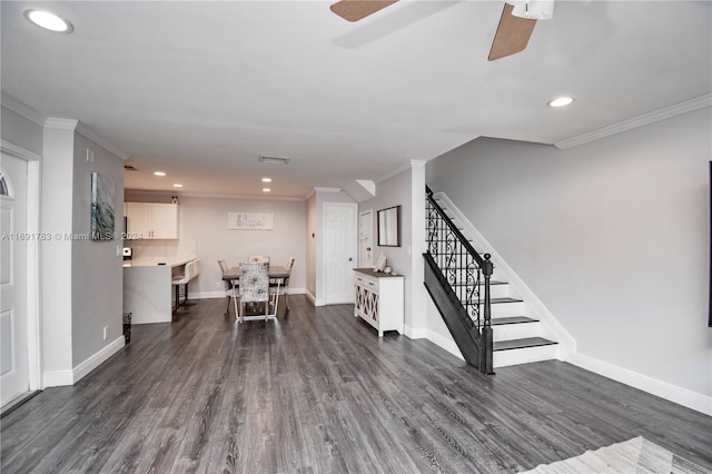 interior space featuring ceiling fan, crown molding, and dark wood-type flooring