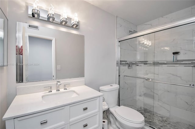 bathroom with vanity, toilet, and a shower with door