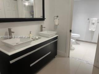 bathroom with vanity, tile patterned flooring, a bidet, and toilet