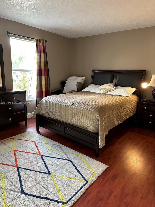 bedroom with a textured ceiling and hardwood / wood-style flooring