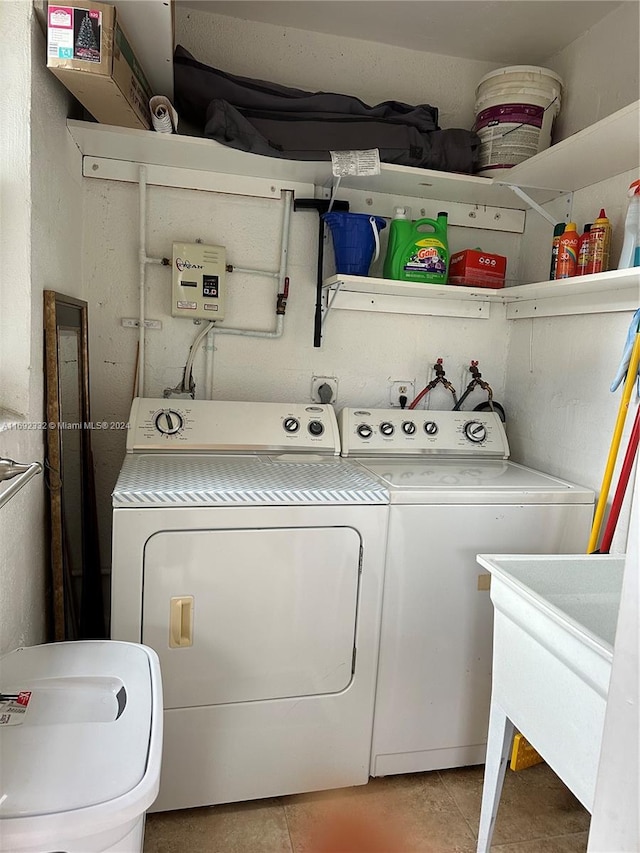 laundry area with sink, independent washer and dryer, and light tile patterned flooring