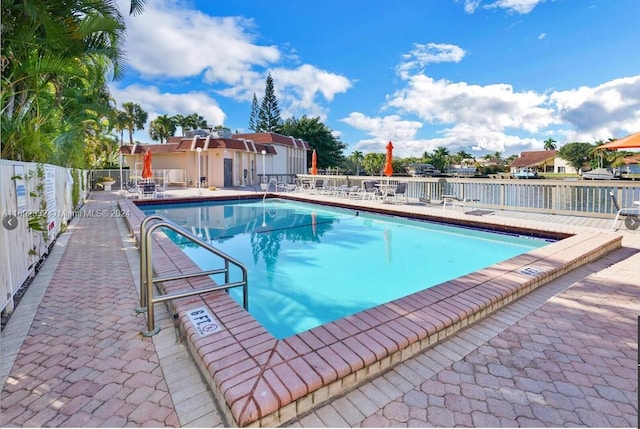 view of swimming pool with a patio and a water view