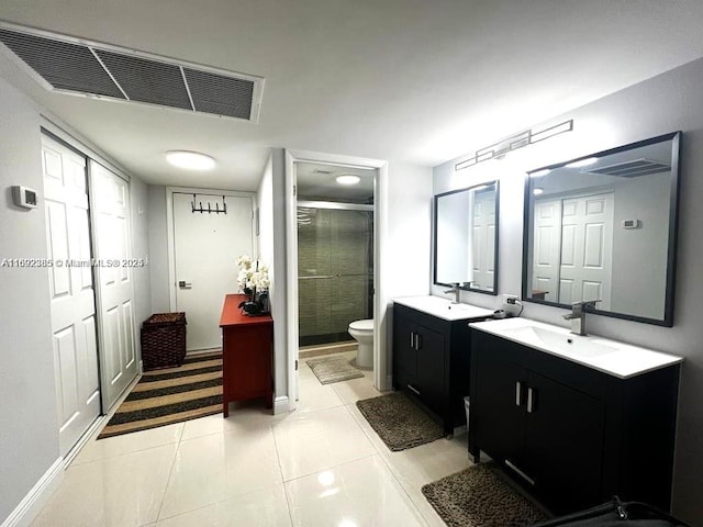 bathroom featuring tile patterned flooring, vanity, an enclosed shower, and toilet