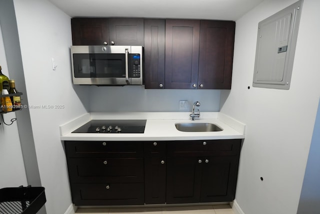 209 N Fort Lauderdale Beach Blvd Unit 7D, Fort Lauderdale, FL 33304 - kitchen with stainless steel microwave, electric panel, a sink, black electric stovetop, and light countertops