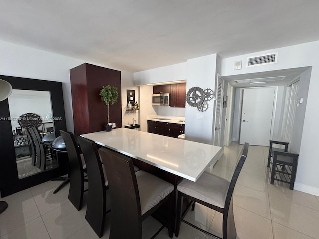 kitchen featuring black electric cooktop, a breakfast bar, and light tile patterned floors