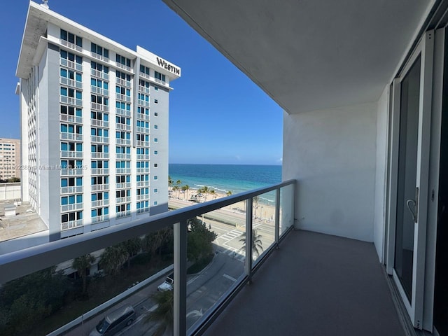 balcony with a water view and a view of the beach