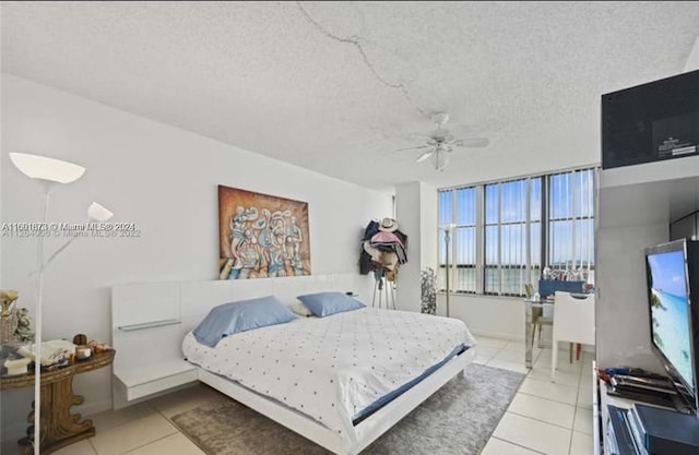 tiled bedroom featuring ceiling fan and a textured ceiling