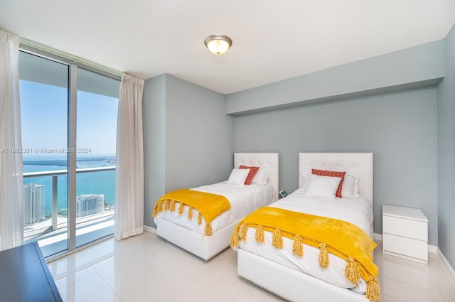 bedroom with access to outside, a water view, and a wall of windows