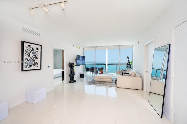 tiled living room featuring expansive windows and rail lighting