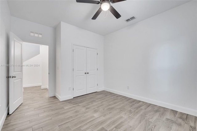 unfurnished bedroom featuring a closet, light hardwood / wood-style floors, and ceiling fan